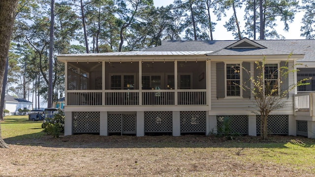 rear view of house with a yard and a sunroom