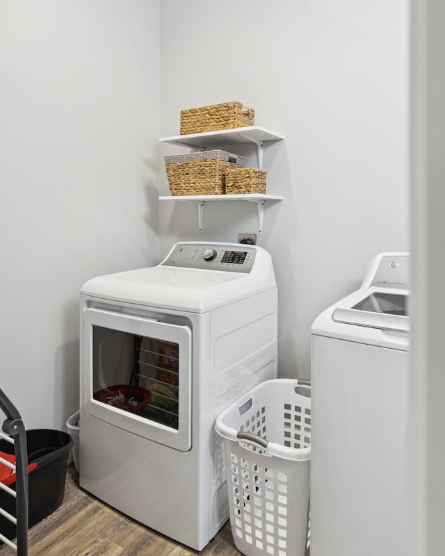 clothes washing area with hardwood / wood-style floors and independent washer and dryer