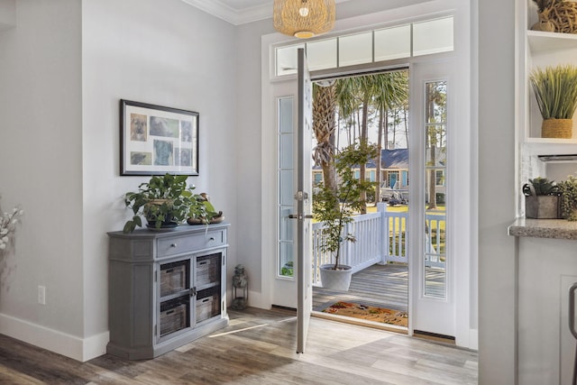 doorway with crown molding and light hardwood / wood-style flooring