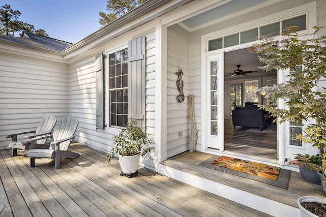 entrance to property featuring ceiling fan and a deck