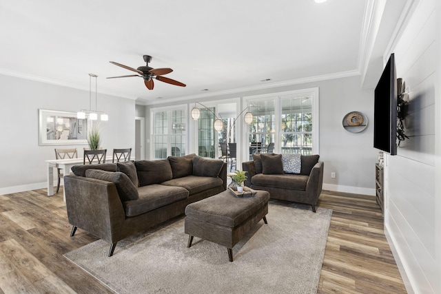 living room featuring wood-type flooring, ornamental molding, and ceiling fan