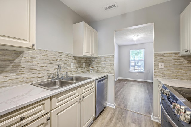 8028 Vermont Rd, North Charleston, SC 29418 - kitchen featuring appliances with stainless steel finishes, a sink, light wood-style flooring, decorative backsplash, and a textured ceiling