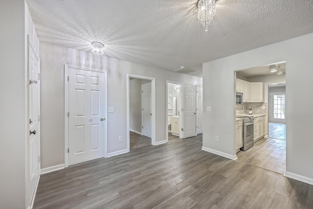 8028 Vermont Rd, North Charleston, SC 29418 - unfurnished living room featuring wood finished floors, a textured ceiling, a chandelier, and baseboards