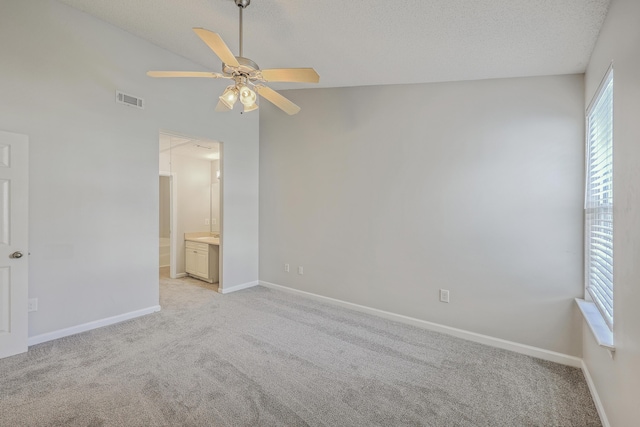 8028 Vermont Rd, North Charleston, SC 29418 - unfurnished bedroom featuring light carpet, baseboards, vaulted ceiling, connected bathroom, and a textured ceiling