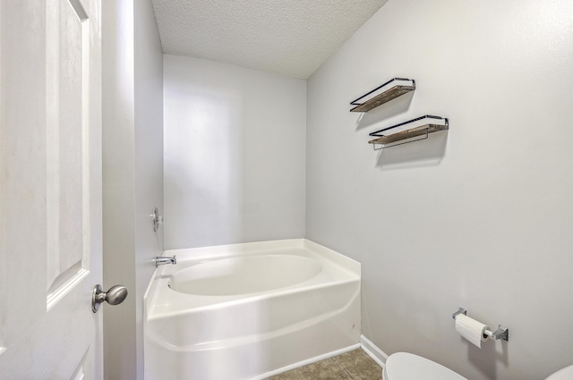 8028 Vermont Rd, North Charleston, SC 29418 - full bathroom featuring a bath, toilet, a textured ceiling, tile patterned flooring, and baseboards
