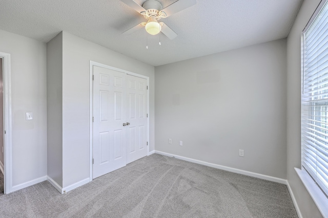 8028 Vermont Rd, North Charleston, SC 29418 - unfurnished bedroom featuring carpet, multiple windows, a textured ceiling, baseboards, and a ceiling fan
