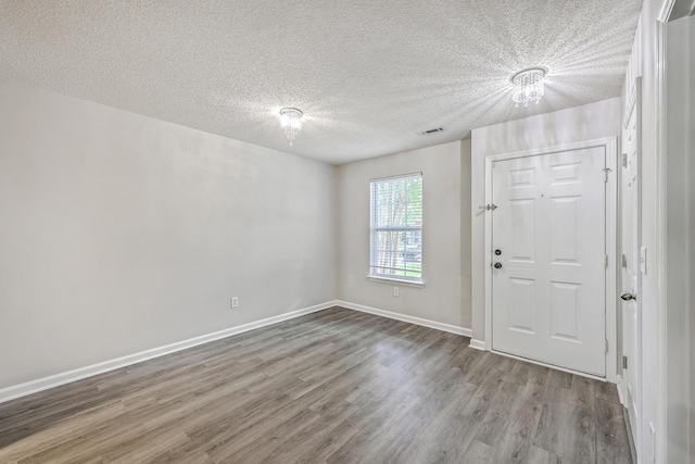8028 Vermont Rd, North Charleston, SC 29418 - entrance foyer with wood finished floors, a textured ceiling, a chandelier, and baseboards