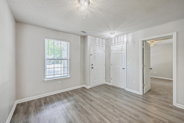 8028 Vermont Rd, North Charleston, SC 29418 - empty room with wood finished floors, a textured ceiling, and baseboards