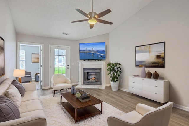 8028 Vermont Rd, North Charleston, SC 29418 - living room featuring wood finished floors, lofted ceiling, ceiling fan, a tiled fireplace, and baseboards