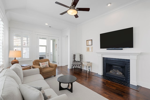 living room with a fireplace, ceiling fan, dark hardwood / wood-style flooring, and ornamental molding