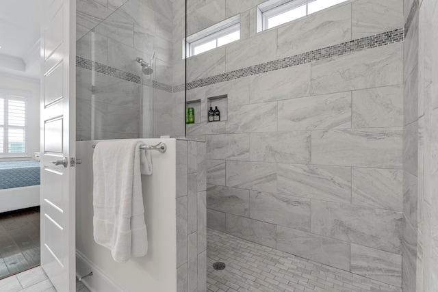 bathroom with a tile shower and hardwood / wood-style flooring