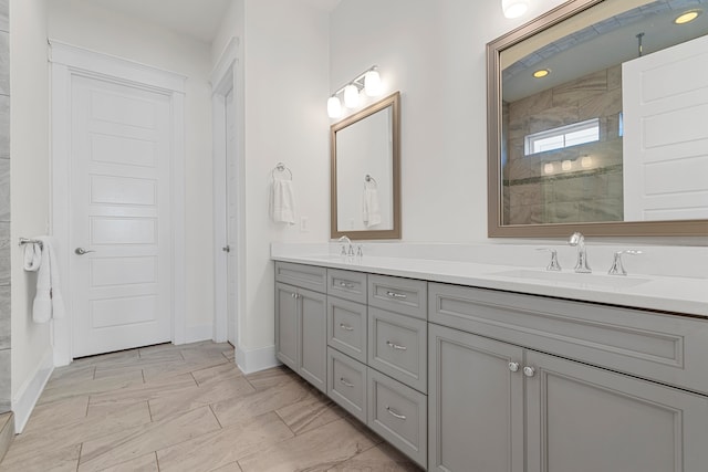 bathroom with a tile shower and vanity