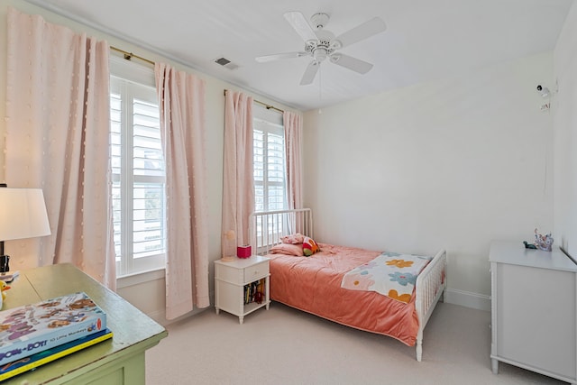 bedroom featuring light carpet, multiple windows, and ceiling fan