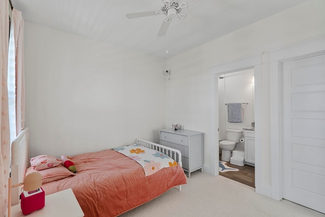 bedroom featuring connected bathroom, light colored carpet, and ceiling fan