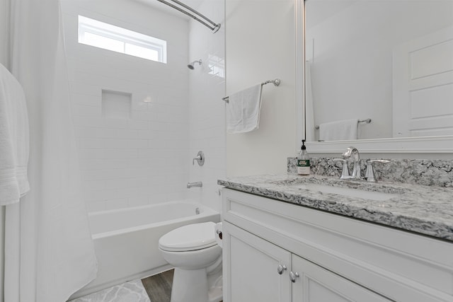 full bathroom featuring hardwood / wood-style flooring, vanity, shower / bath combination with curtain, and toilet