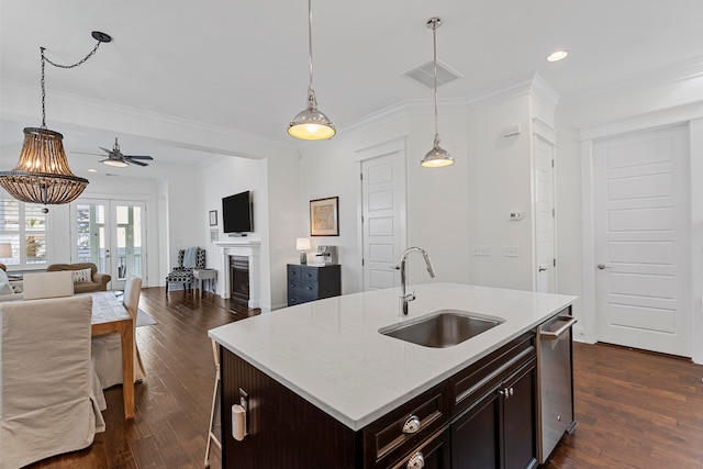 kitchen featuring a kitchen island with sink, sink, crown molding, ceiling fan, and dark hardwood / wood-style flooring