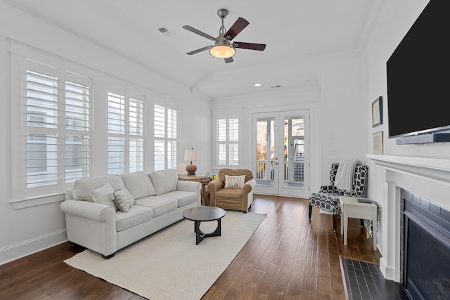 living room with a wealth of natural light, crown molding, ceiling fan, and dark hardwood / wood-style floors