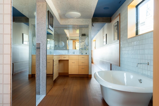 905 Palm Blvd, Isle Of Palms, SC 29451 - bathroom featuring tile walls, a freestanding tub, wood-type flooring, plenty of natural light, and vanity