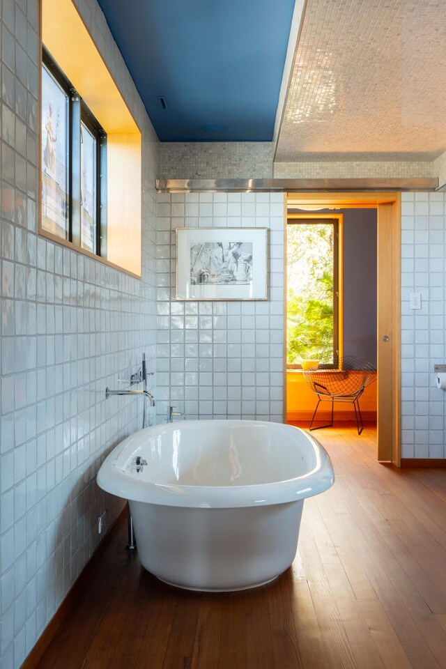 905 Palm Blvd, Isle Of Palms, SC 29451 - bathroom featuring tile walls, hardwood / wood-style flooring, and a freestanding bath