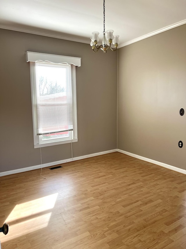 unfurnished room featuring crown molding, an inviting chandelier, and hardwood / wood-style floors