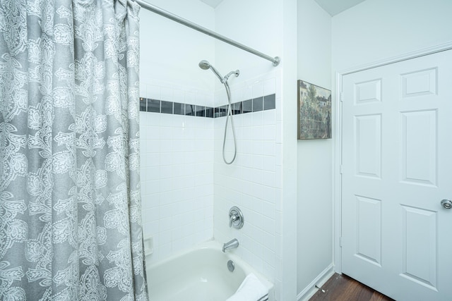 bathroom featuring shower / bath combo with shower curtain, wood finished floors, and baseboards