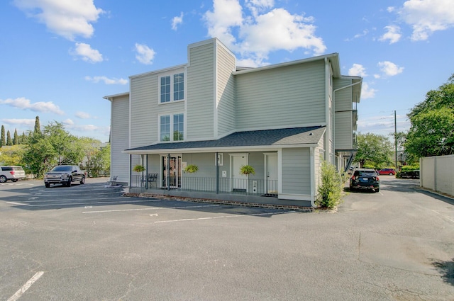 view of front facade with uncovered parking and covered porch