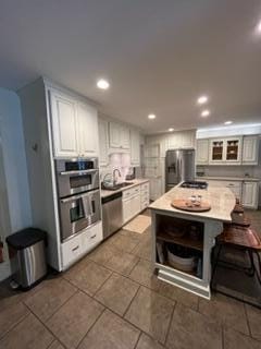 kitchen featuring sink, white cabinetry, stainless steel appliances, and a kitchen island