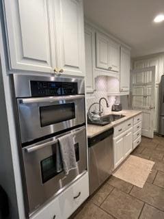 kitchen featuring sink, stainless steel appliances, and white cabinets