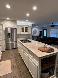 kitchen featuring white cabinetry, a center island, ceiling fan, and appliances with stainless steel finishes