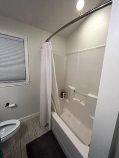 bathroom with toilet and shower / tub combo