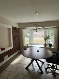 dining area featuring brick wall