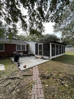 back of property with a sunroom and a patio