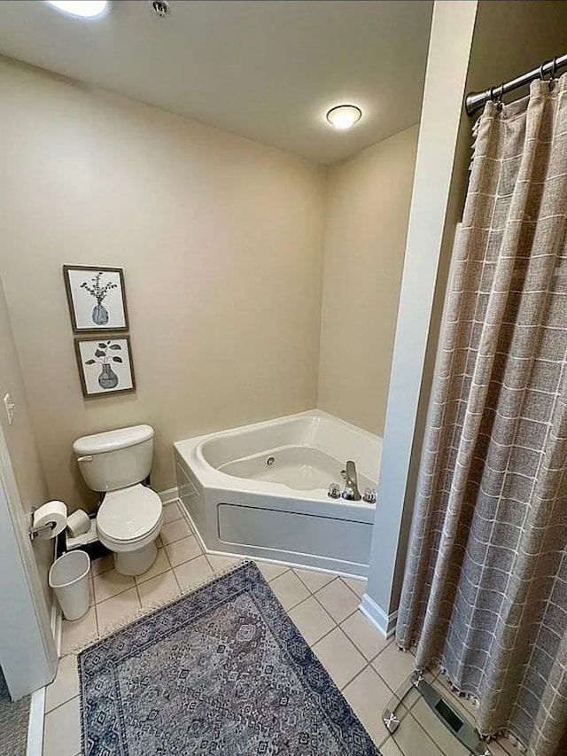 bathroom with tile patterned floors, toilet, and a bath