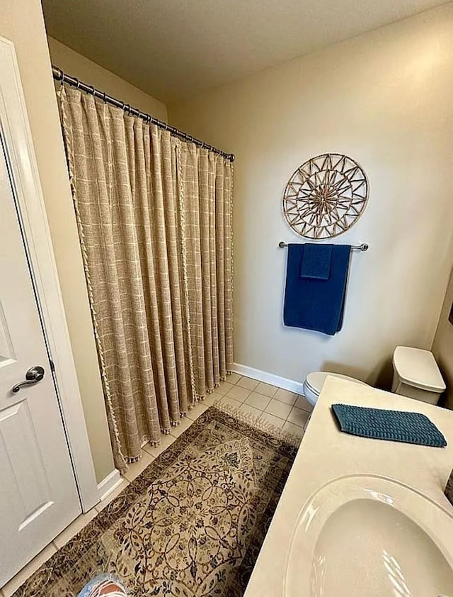 bathroom with tile patterned floors, a shower with curtain, vanity, and toilet