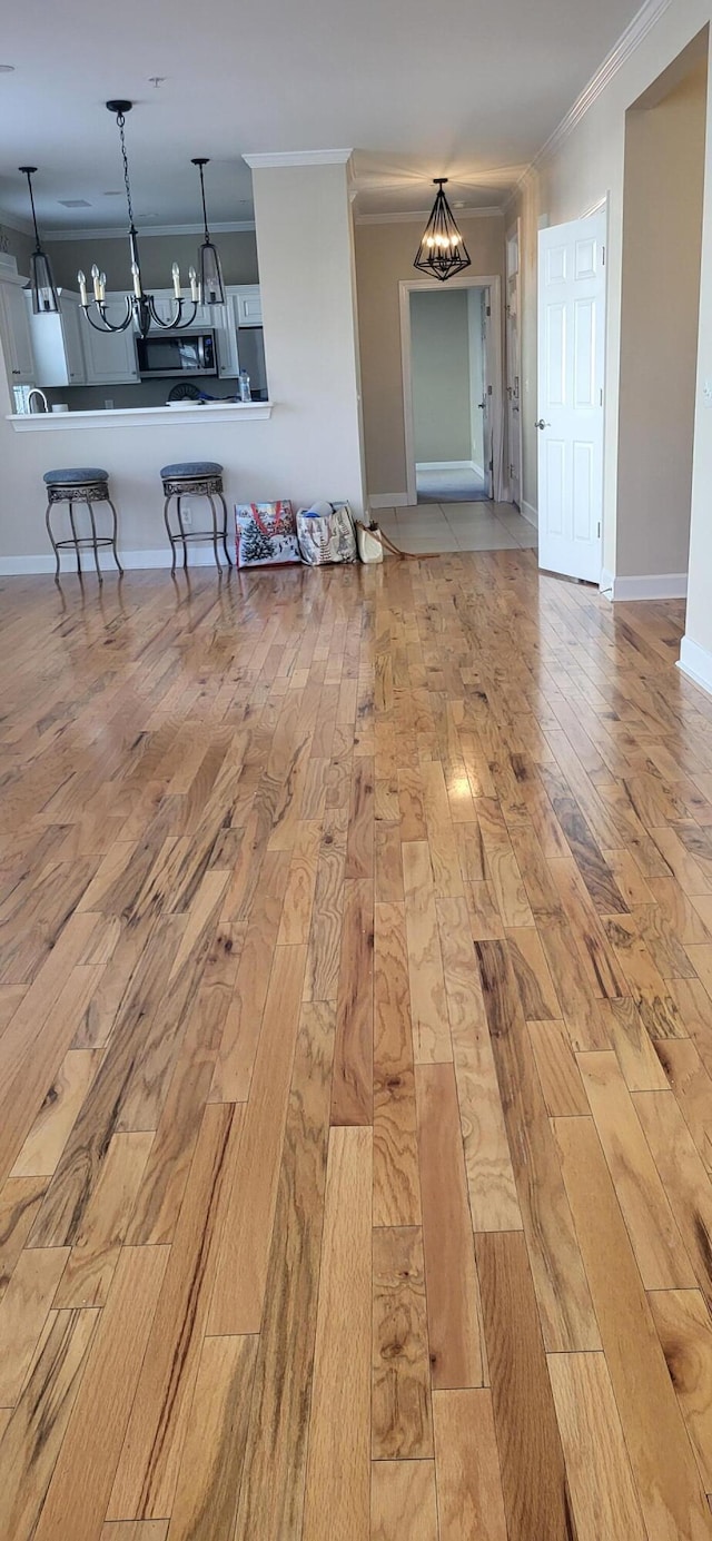 unfurnished living room with crown molding and light hardwood / wood-style flooring