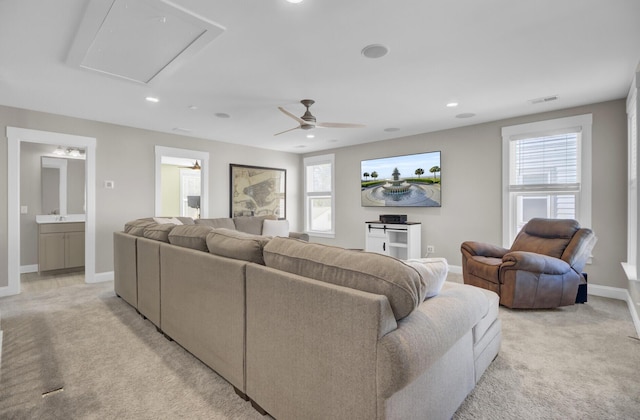 living area featuring baseboards, attic access, recessed lighting, ceiling fan, and light colored carpet