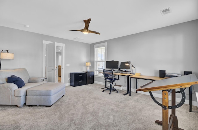 carpeted home office with a ceiling fan, baseboards, and visible vents