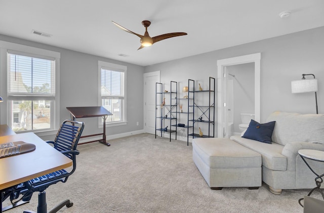 office space featuring visible vents, carpet flooring, a ceiling fan, and baseboards