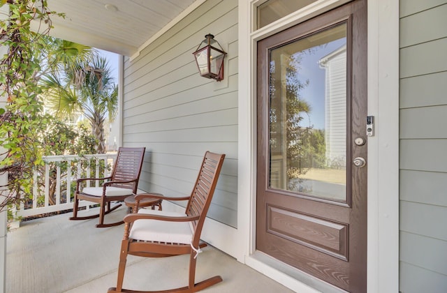 view of exterior entry featuring covered porch