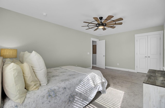 carpeted bedroom featuring a closet, baseboards, and a ceiling fan