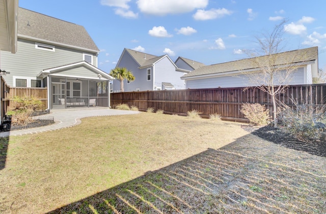 view of yard with a patio area, a fenced backyard, and a sunroom