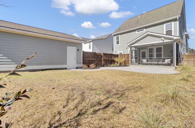 rear view of property featuring a patio area, a lawn, a fenced backyard, and a sunroom