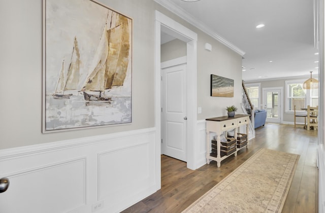 hallway featuring recessed lighting, wood finished floors, ornamental molding, and wainscoting