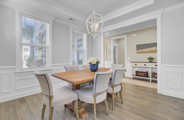 dining space featuring a notable chandelier, plenty of natural light, visible vents, and wood finished floors