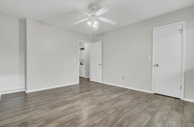 spare room featuring baseboards, a ceiling fan, and wood finished floors