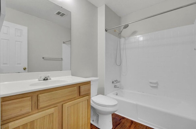 bathroom with visible vents, toilet, washtub / shower combination, vanity, and wood finished floors