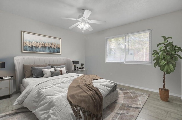 bedroom featuring light wood-type flooring, ceiling fan, and baseboards