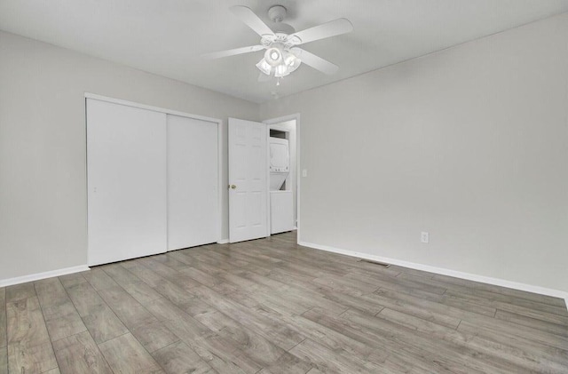 unfurnished bedroom with visible vents, a closet, baseboards, and wood finished floors