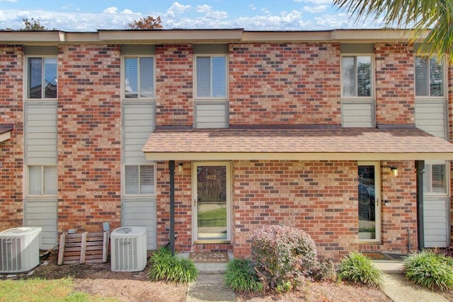 view of front of house featuring central AC and brick siding