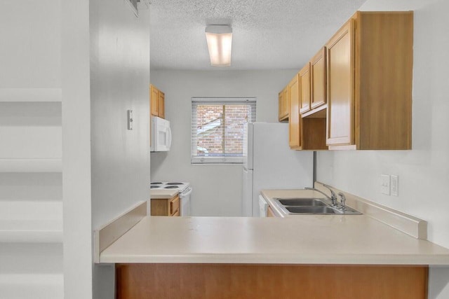 kitchen featuring white appliances, a textured ceiling, light countertops, and a sink